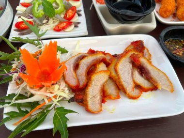 Soya soslu ızgara domuz eti ve beyaz tabakta salata..