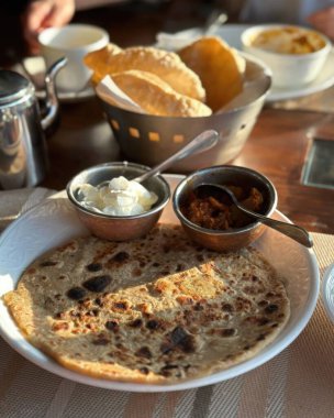 Süzme peynirli ev yapımı krepler ve ahşap masada kuru üzümler.