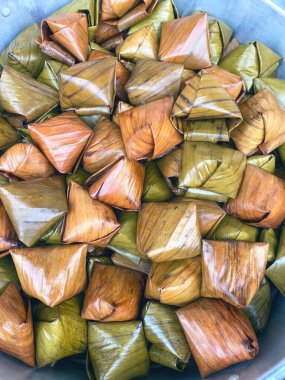 Canlı yeşil muz yapraklarına sarılmış lezzetli Tayland tatlıları.