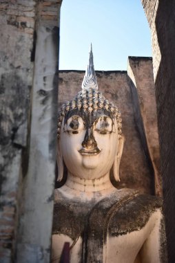 Tarihi bir ortamda barış ve ruhaniliği simgeleyen, antik duvarlar arasında yakalanmış dingin bir Buda heykeli..