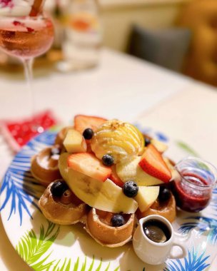 Taze meyvelerle kaplı canlı bir tabak waffle ve bir kepçe dondurma. Kahvaltı ya da rahat bir kafede kahvaltı için mükemmel..