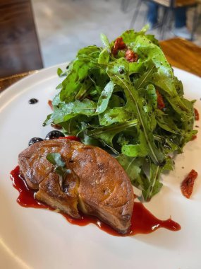 Lezzetli bir sosun içine serpiştirilmiş taze yeşil salata serpiştirilmiş taze protein içeren çok güzel sunulmuş bir yemek. Gurme deneyimi için mükemmel..