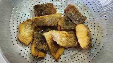 Metal bir süzgeçte duran kızarmış balık parçalarının yakın çekim görüntüsü. Yemek fotoğrafçılığı için mükemmel. Bu yemek, yemek ya da atıştırmalık için ideal dokuları sergiliyor..