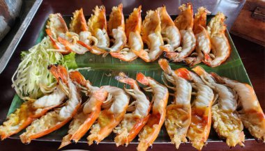 Izgara karides tabağı, yeşil muz yaprağında servis edilir.