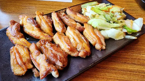 Taze salatayla birlikte ızgara tavuk kanadı sergilenecek. Bu yemek, her yemek için mükemmel olan zengin lezzetleri ve çekici renkleri ön plana çıkarıyor..