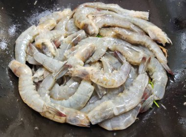 Harika bir taze çiğ karides gösterisi. Mutfak yaratımı için mükemmel. Deniz ürünleri yemekleri için idealdir, bu resim canlı renkleri ve malzemelerin doğal kalitesini vurgular..