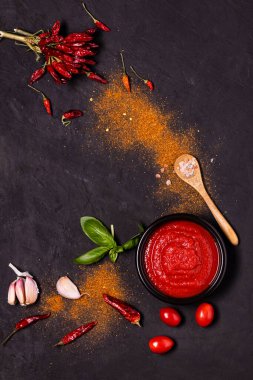 Biraz sarımsak ve kuru biber, taze fesleğen ve domates soslu kase. İtalyan mutfağı.