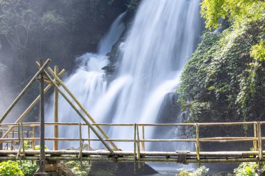 Kuzey Tayland 'da bir Karen kabilesi köyünün yakınındaki bir şelaleden geçen bambu köprü manzarası..