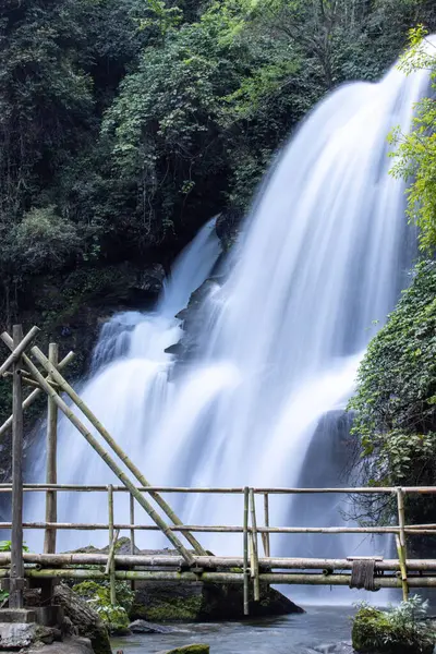 Kuzey Tayland 'da bir Karen kabilesi köyünün yakınındaki bir şelaleden geçen bambu köprü manzarası..