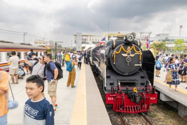 Nakhon Pathom, Tayland - 4 Mayıs 2025: Turistler ve yolcular özel bir tren yolculuğu sırasında tarihi bir Japon Pasifik buharlı lokomotifinin fotoğraflarını çekiyorlar. Nakhon Pathom.
