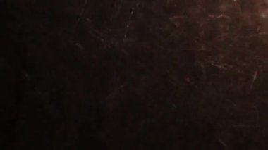 Işığın altında asfalt zemine şiddetli yağmur yağıyor yapay ışık altında kayboluyor.