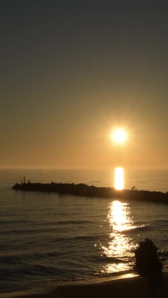 ビーチの岩の中の夕日 4K垂直 — ストック動画