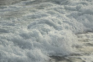 Gün batımında köpükle dalgalı deniz dalgaları