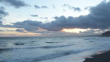 Gün batımında krepuscule plajında beyaz köpüklü deniz dalgaları. Yavaş Hareket