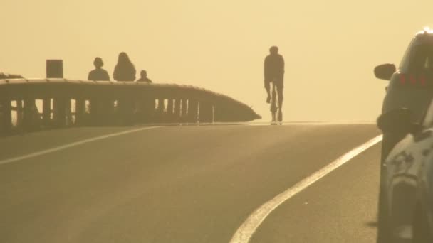 Radfahrer Bei Sonnenuntergang Auf Einer Straße Mit Autos — Stockvideo