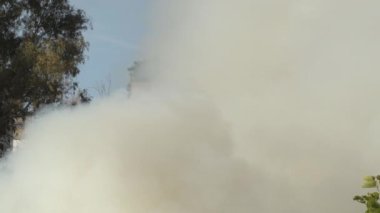 Büyük beyaz duman sütunu gerçek bir yangında yükseliyor.