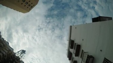 Bulutlu ve binalı bir gökyüzü. Birinci kişi görünümü