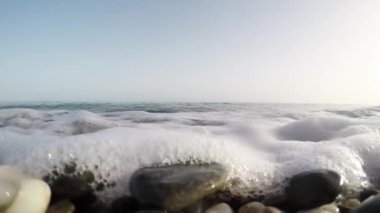 Bir yaz günü kameraya yaklaşan küçük dalgalar. Birinci kişi görünümü