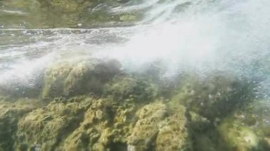 Dalgalar su altında bir kayaya çarpıyor.