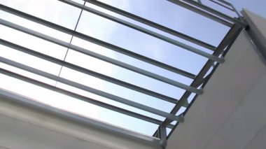 Endüstriyel bir deponun ön cephesinde mavi gökyüzü olan metal yapı, pan