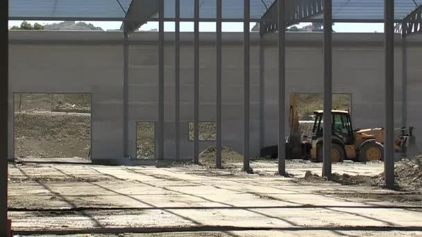 建設中の工業倉庫の内部で作業する掘削機 — ストック動画
