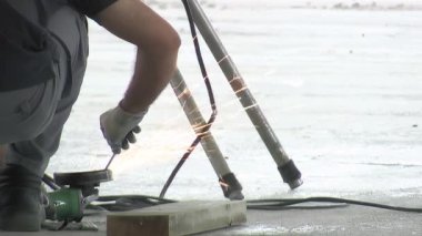 Operatör metal çubukları öğütücüyle biliyor.