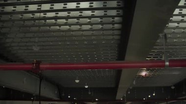 İnşaat halindeki bir deponun metal tepesindeki kırmızı boru anti-yangın, eğik.