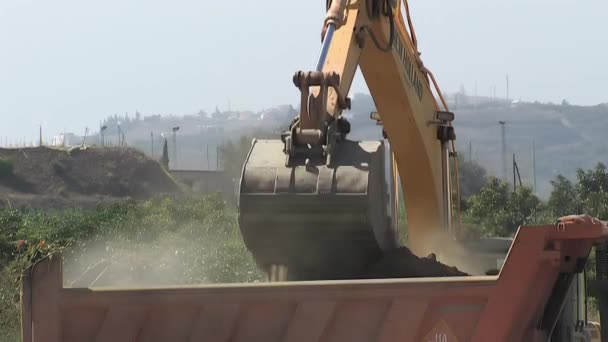 挖掘机在地下挖掘并装载一辆卡车 — 图库视频影像