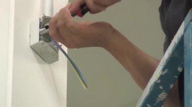 Elektrikçi endüstriyel bir depoya elektrik kutusu yerleştiriyor.