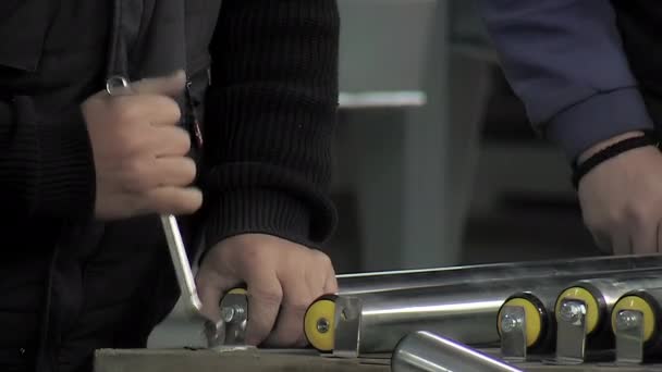 レンチが付いている産業食品加工ラインのローラーを締めるオペレータ — ストック動画