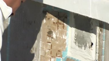 Tuğla ustası taş döşemeleri yeni inşa edilmiş bir sanayi göletine yerleştiriyor.