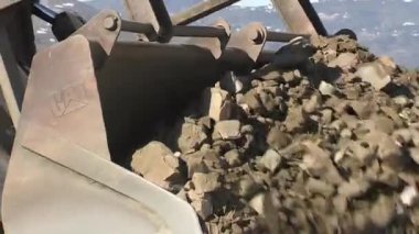 Kürek kazıcısı, endüstriyel bir deponun inşaatına toprak yüklüyor.