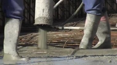 Tuğlacılar inşaatta kullanılan demirden bir zincire beton döküyorlar.