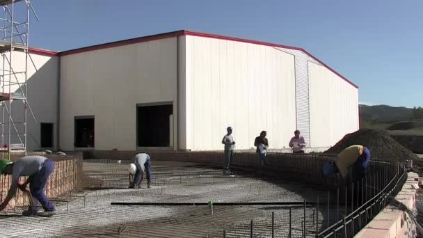 在工业仓库里把铁丝装在锻铁结构中的工人 — 图库视频影像