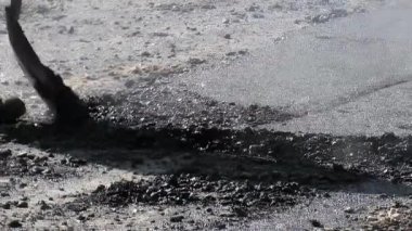 İşçiler yolları kürekle kaplıyor.