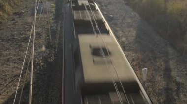 Yolcu treni gün batımında geçip gidiyor.
