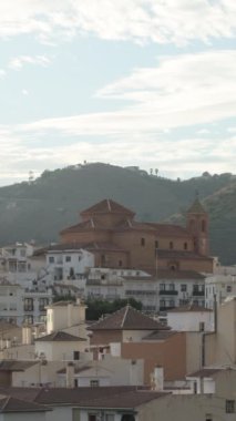 Torrox kilisesi arkadan beyaz evlerle çevrili. 4K Dikey