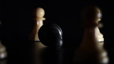 Beyaz piyonlarla çevrili siyah satranç piyonu düştü. Zorbalık.