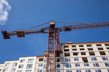 Yeni bir apartman bloğu üzerinde çalışıyoruz. Vinçlerle birlikte inşaat halindeki yüksek bina. Yeni Bina İnşaat Alanı.