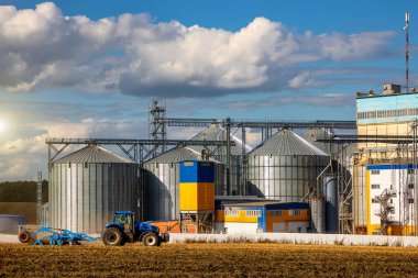 Tarım Siloları. Tahıl depolama ve kurutma tahıl, buğday, mısır, soya, ayçiçeği beyaz bulutlu mavi gökyüzüne karşı. Ekin depolama