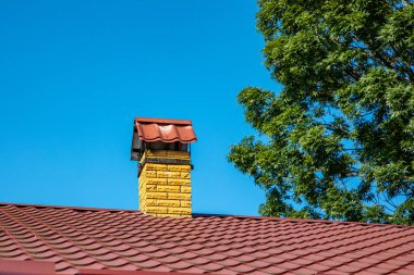 Evin çatısında duman çıkarmak için egzoz borusu var.