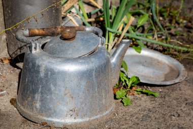 Garajın yakınındaki eski alüminyum çaydanlık..