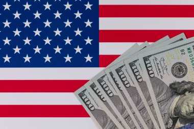 Amerika Birleşik Devletleri bayrağının arka planına karşı 100 Amerikan doları.