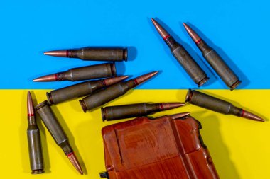 Bir makineli tüfek fişeği ve Ukrayna bayrağının arkasında bir şarjör. Ukrayna 'da Savaş.