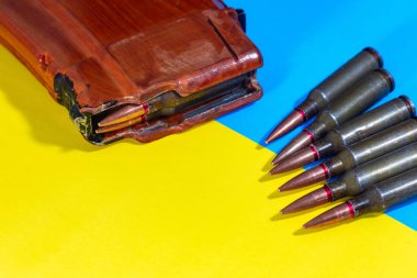 Bir makineli tüfek fişeği ve Ukrayna bayrağının arkasında bir şarjör. Ukrayna 'da Savaş.