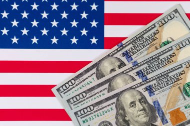 Amerika Birleşik Devletleri bayrağının arka planına karşı 100 Amerikan doları.