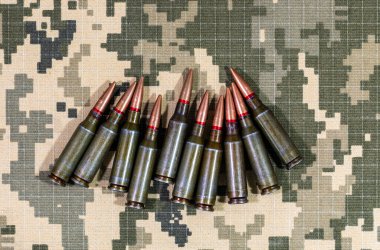 Ukrayna ordusunun piksel kamuflaj üniformasının arka planında bulunan makineli tüfekten çıkan bir fişek. Ukrayna 'da Savaş.