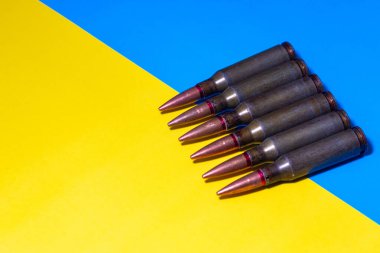 Ukrayna bayrağının arka planında makineli tüfek fişekleri var. Ukrayna 'da Savaş.