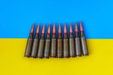 Ukrayna bayrağının arka planında makineli tüfek fişekleri var. Ukrayna 'da Savaş.