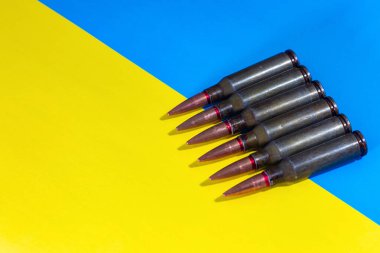 Ukrayna bayrağının arka planında makineli tüfek fişekleri var. Ukrayna 'da Savaş.